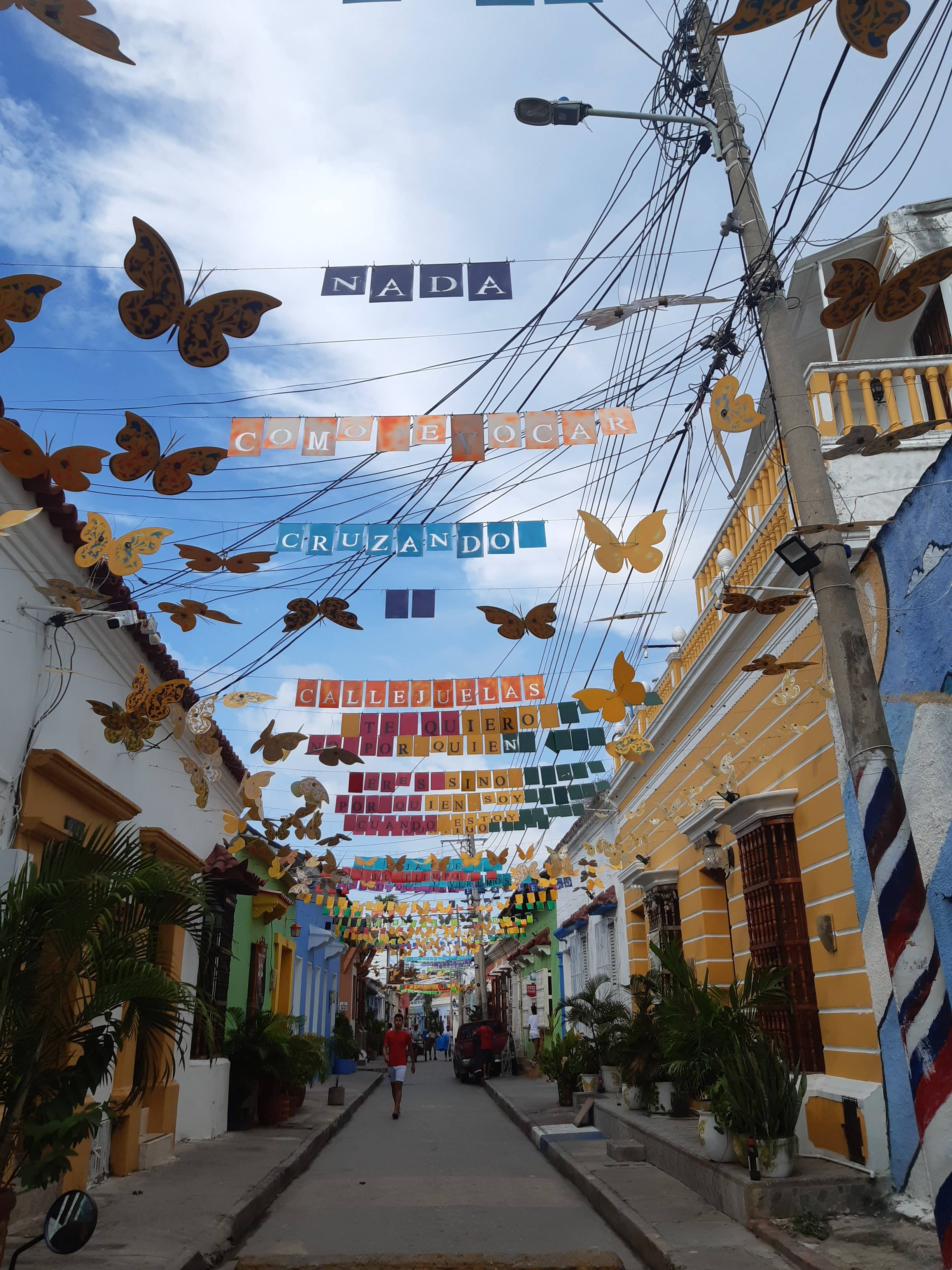 Calle estrecha decorada con sombrillas de colores