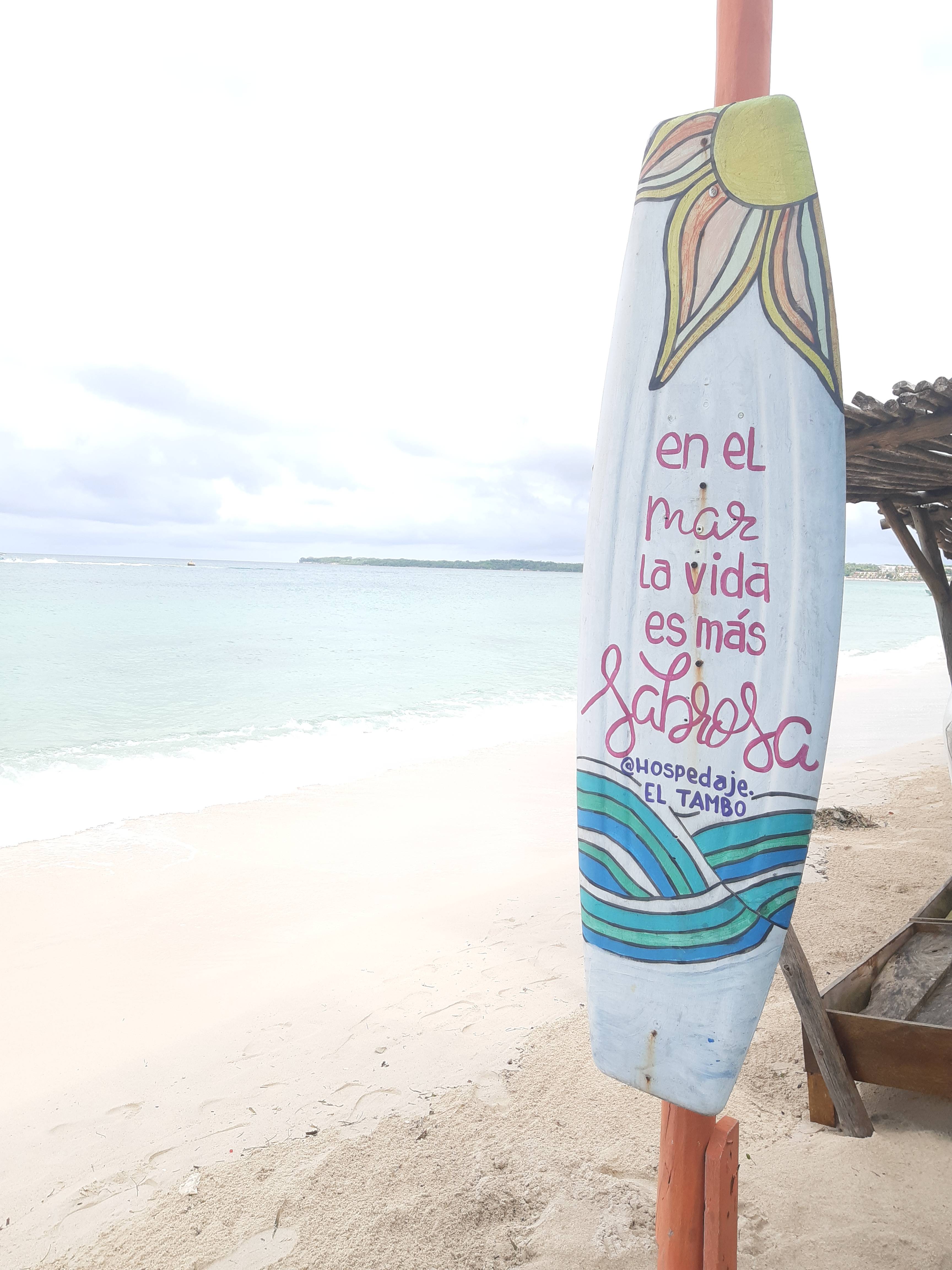 Tabla pintada con motifs caribeños en la playa